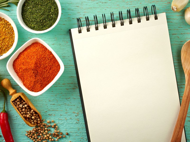 notepad surrounded by spices and spoon