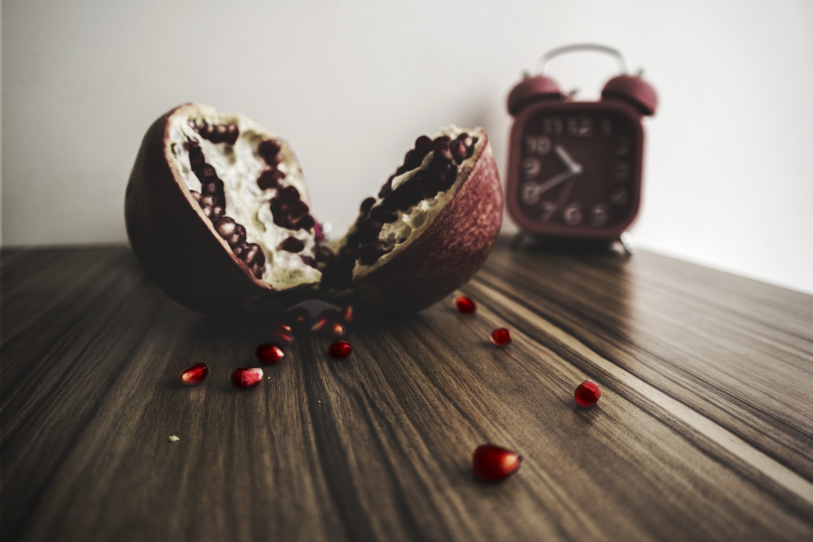 pomegranate and clock on table