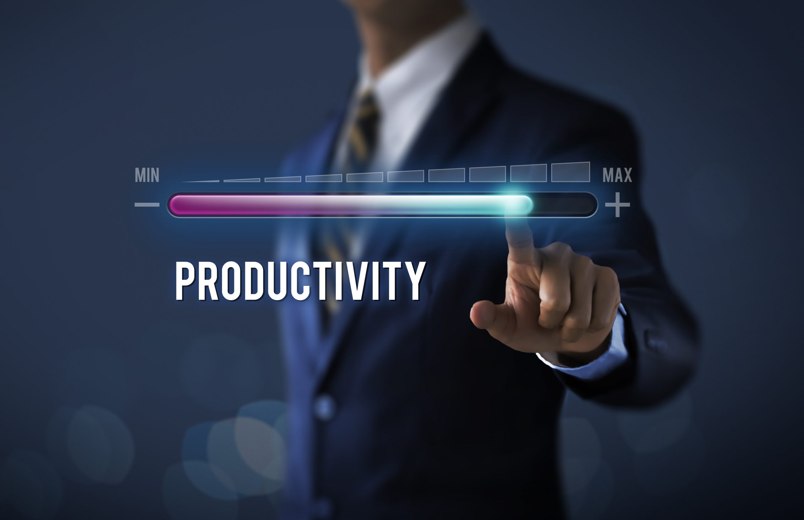 Increase productivity concept. Businessman is pulling up progress bar with the word PRODUCTIVITY on dark tone background.
